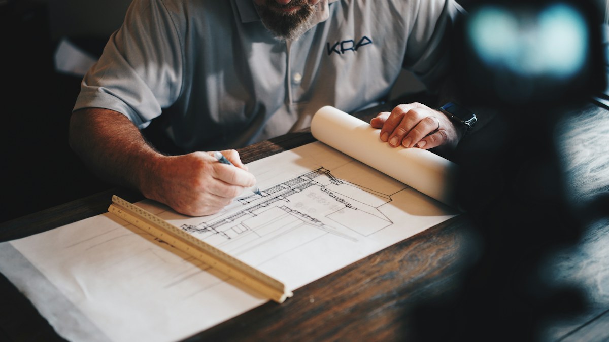 A contractor working over building plans
